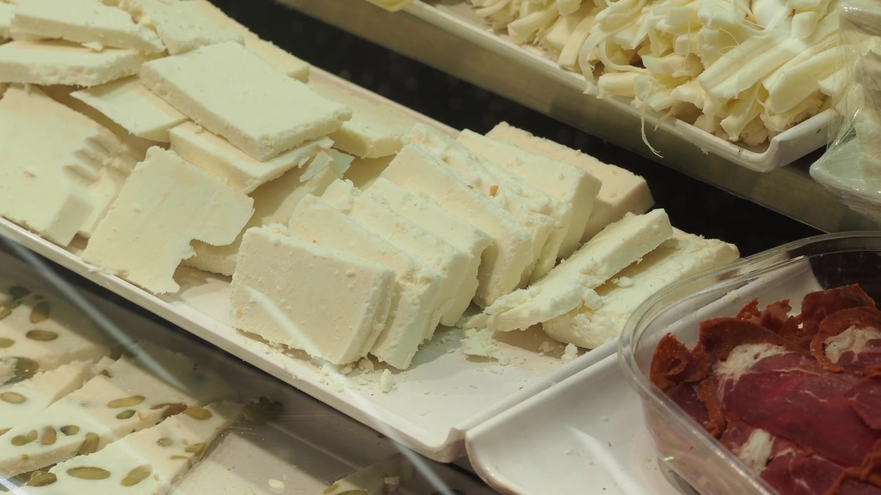 Fresh Feta Cheese Blocks and Sliced Pastrami in a Deli Display