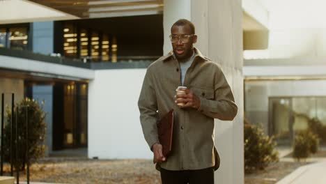 businessman enjoying coffee outdoors near modern office buildings