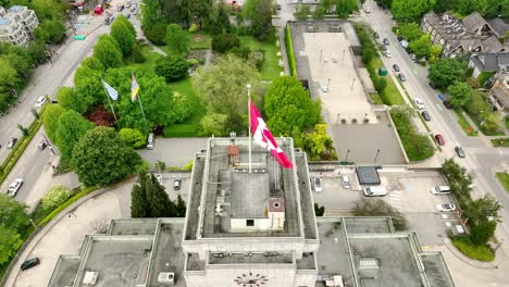 ayuntamiento de vancouver con bandera canadiense en su techo durante el día en vancouver, bc, canadá