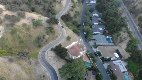 aerial of neighborhood houses and street nestled in a valley between mountains