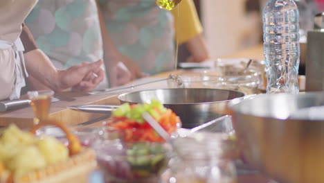 chef pouring oil on pan at cooking master class