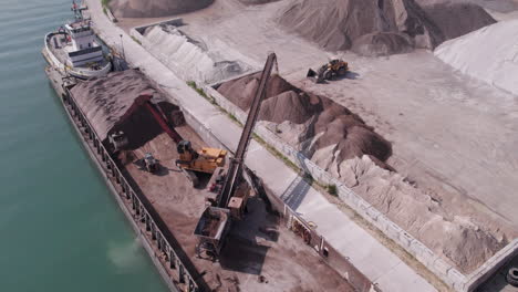 aerial view of a heavy machine loading gravel in sliding machinery in kingsville harbour