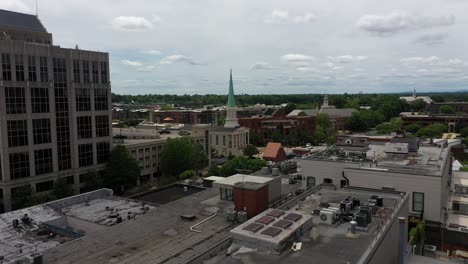 toma aérea de greenville en carolina del sur, calle con edificios históricos y autos conduciendo en un día nublado