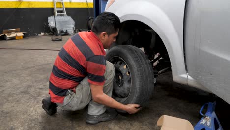 Professional-Skilled-Latino-mechanic-repairing-tire-in-automotive-shop