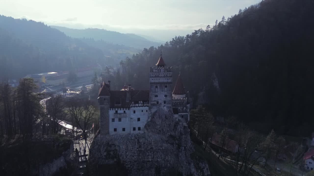 Epico avvicinamento con drone al leggendario Castello di Bran in Transilvania, Romania, noto come Castello di Dracula, caratterizzato da un'atmosfera oscura e misteriosa e architettura medievale su una drammatica scogliera
