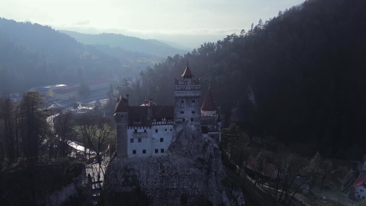 Epico avvicinamento con drone al leggendario Castello di Bran in Transilvania, Romania, noto come Castello di Dracula, caratterizzato da un'atmosfera oscura e misteriosa e architettura medievale su una drammatica scogliera