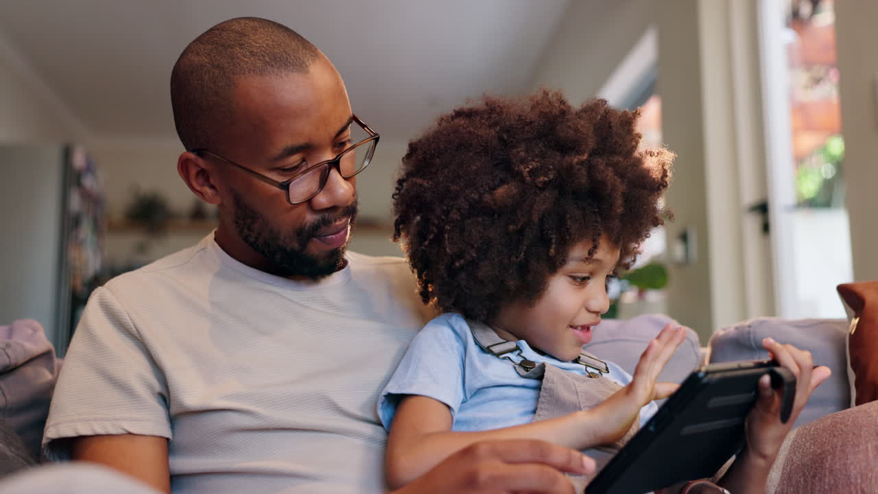 Padre e figlio che usano un tablet insieme a casa