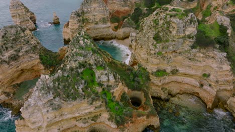 Toma-Panorámica-De-La-Escarpada-Costa-Del-Algarve,-Volando-A-Través-De-Las-Rocas