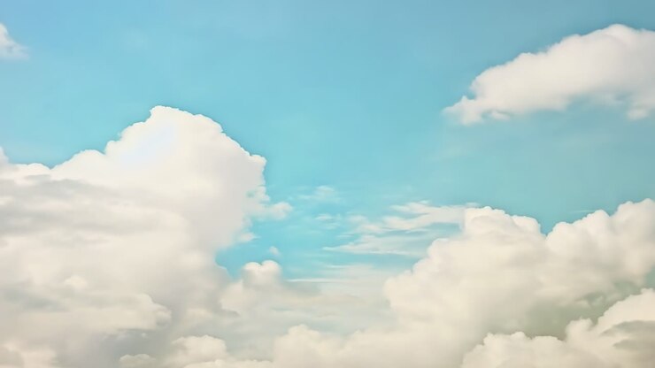 A serene video of fluffy clouds against a blue sky, captured from a low angle, creating a peaceful
