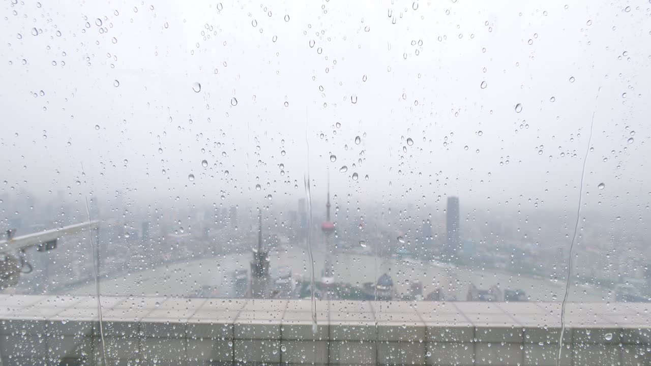 여름에 창문 유리 위에 떨어지는 비 물방울, 느린 동작, 4k 영상, 상하이 의 랜드마크 배경과 함께 강한 비가 떨어집니다.