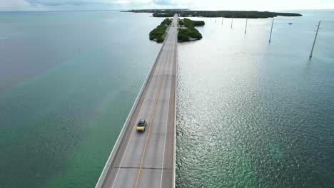 yellow car driving across bridge on florida keys overseas highway