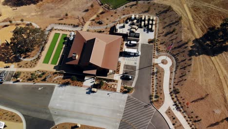 Aerial-fly-through-of-an-RV-Park-at-Sunset-showing-the-entrance-and-RV-spots-and-pool-area