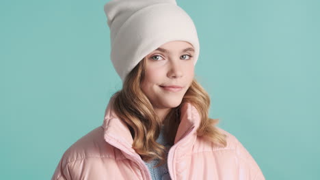 teenage caucasian girl with winter clothes making faces in front of the camera.