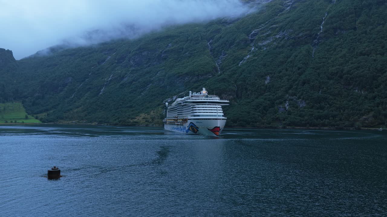 Nave da crociera in partenza da Geiranger attraverso un maestoso fiordo, vista aerea