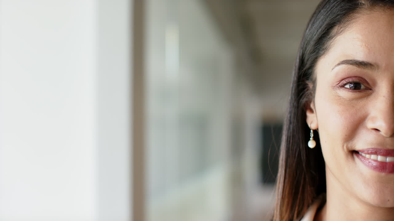 Smiling woman wearing pearl earring in professional office environment, copy space