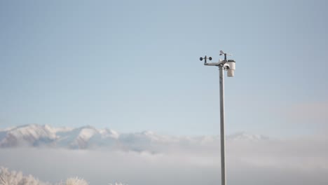 Pole-mounted-weather-station-in-front-of-majestic-snowy-mountains