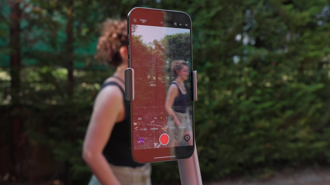Woman Outdoor Recording Video With Smartphone Mounted On AI Tracking Gimbal Stabilizer. closeup shot