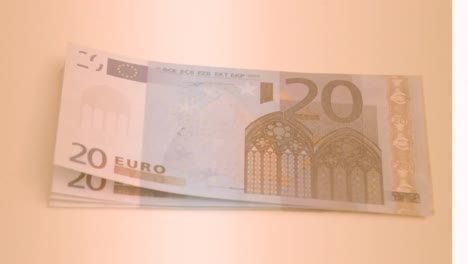 animation of close up of euro bills flying against orange background