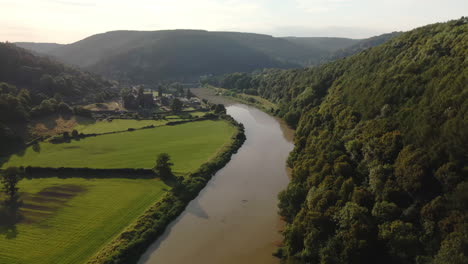 aerial drone footage of the river wye and tintern abbey on a sunny summer day, capturing scenic landscapes and historic architecture.