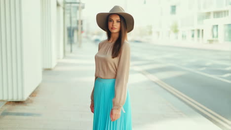 fashionable woman in hat and blue skirt on an urban street