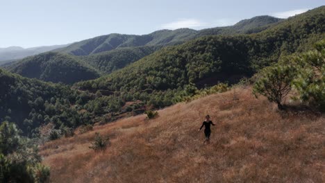 female adventurer hiking across chinese mountainside in yunnan province, aerial