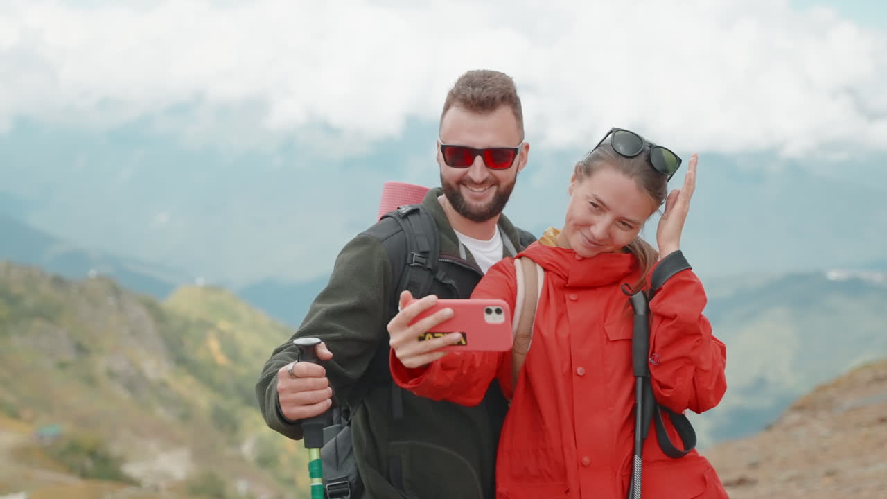 una pareja tomando una selfie en las montañas.