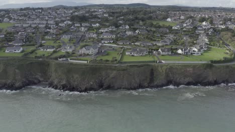 Vuelo-Aéreo:-Acantilados-Rocosos-Junto-Al-Mar-En-Tramore,-Irlanda-Del-Sur