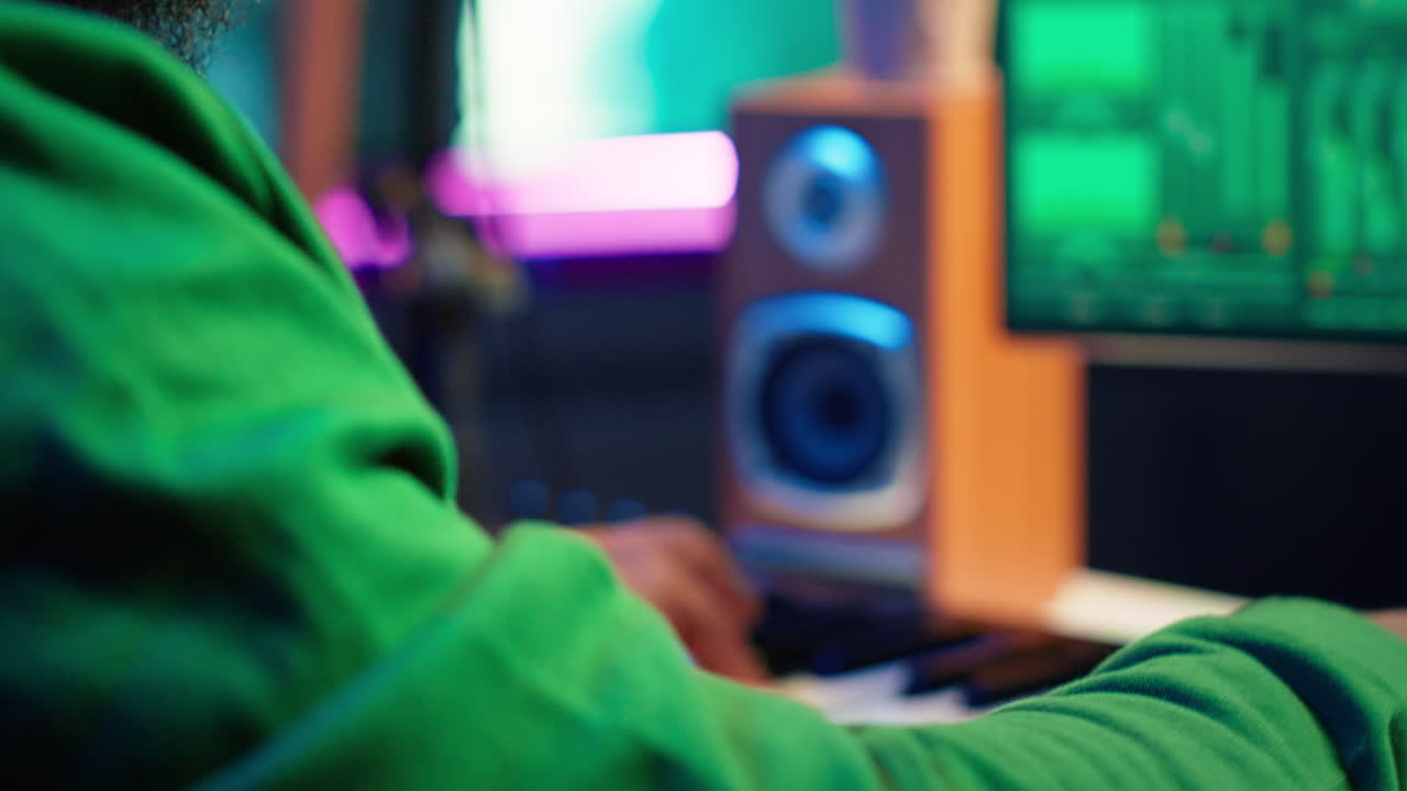 ingeniero de sonido tocando el piano y mezclando melodías en software digital