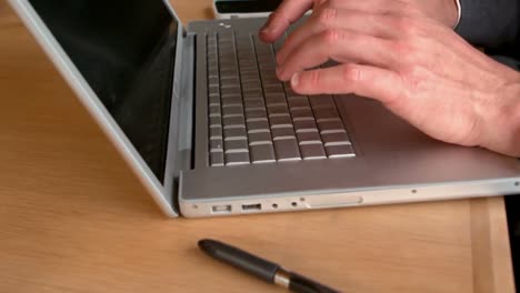 Businessmans-hands-typing-on-laptop-keyboard