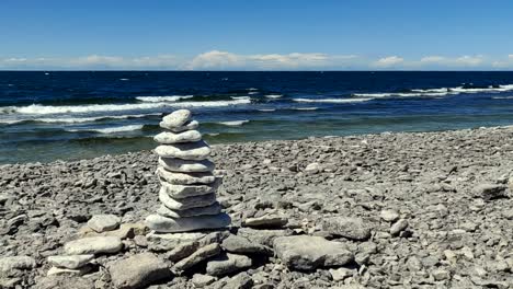 pile of rocks, on the coast of gotland, waves in the background, on a windy, summer day, in sweden - static view