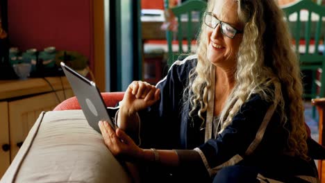 mujer madura usando tableta digital en la sala de estar 4k