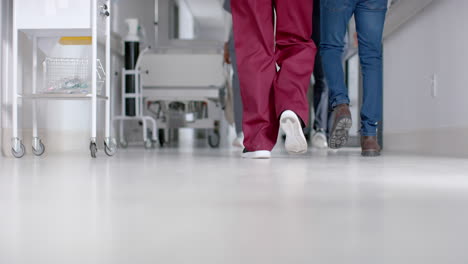 Sección-Media-De-Diversos-Médicos,-Hombres-Y-Mujeres,-Caminando-En-El-Pasillo-Del-Hospital,-Cámara-Lenta