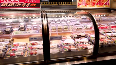 customer browsing sushi in a refrigerated grocery aisle