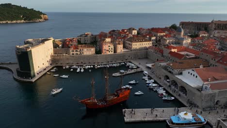 view of dubrovnik harbor featuring yachts docked opposite a majestic sailing ship