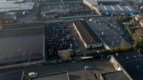 wide aerial of car junkyard on industrial site
