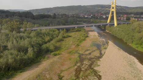 vuelo aéreo sobre un río que se está secando y un puente automático en europa