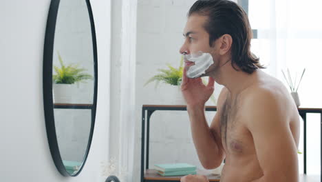 hombre afeitándose en el baño