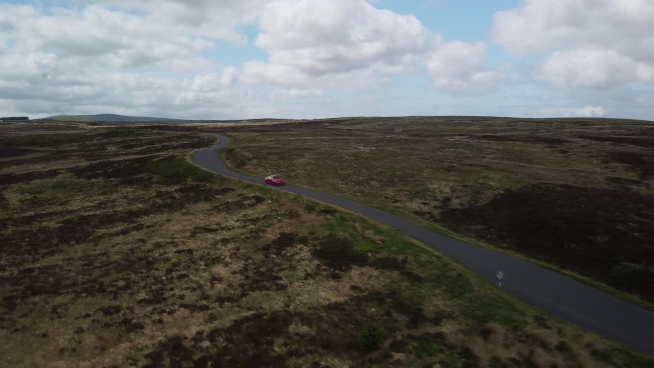 시골 의 단일 트랙 도로 를 따라 이동 하는 빨간 차 의 앞면