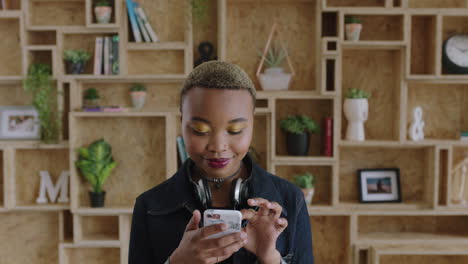 Retrato-De-Una-Joven-Afroamericana-Independiente-Enviando-Mensajes-De-Texto-Navegando-Usando-Un-Teléfono-Inteligente-Sonriendo-Conectado