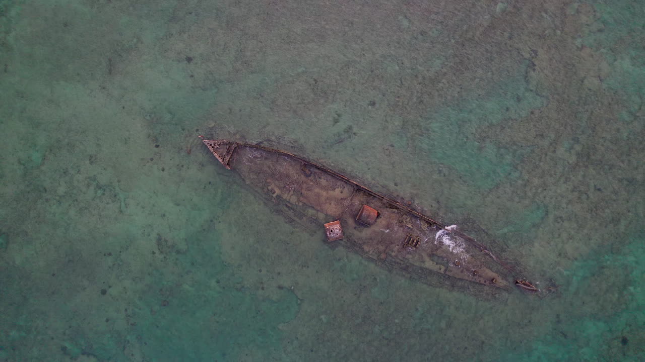 Ripresa aerea dall'alto del relitto della Mildura vicino a Exmouth che rivela la barriera corallina circostante, l'acqua bassa e i motivi naturali, evidenziando texture e caratteristiche marine dall'alto