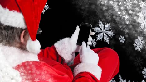 santa using mobile phone with falling snowflakes