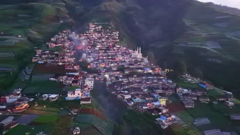 vista aérea de la mañana brumosa sobre el pueblo en la ladera de la colina