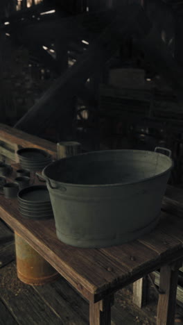 old metal tub on rustic table in abandoned barn