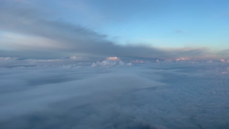 Aerial-cockpit-view,-pilot-pov,-from-a-jet-during-cruise-level-at-sunset,-with-nice-dramatic-clouds,-like-a-dream