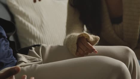 Close-Up-Of-Loving-Young-Couple-Relaxing-At-Home-Sitting-On-Sofa-Holding-Hands-Together-1