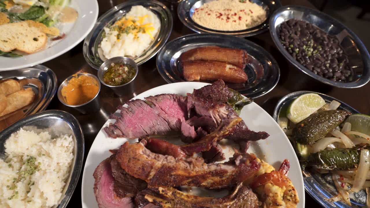mesa llena de varias ofertas en un restaurante de carnes brasileño, cerrar el control deslizante en cámara lenta 4k