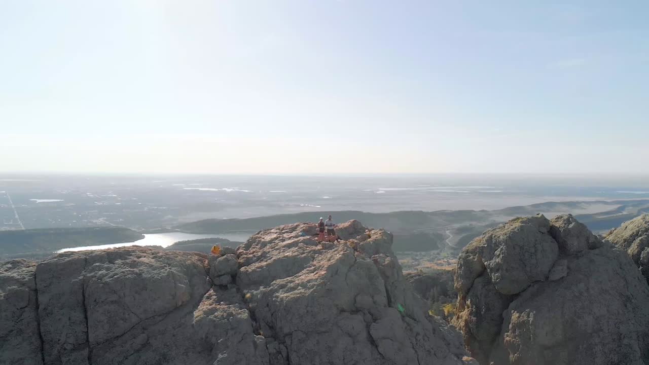 멀리 있는 산악 지형, 등산객 및 도시 풍경의 드론 샷