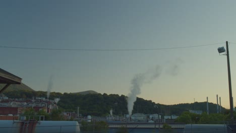 establishing shot of celanese factory releasing smoke into the atmosphere - wide shot