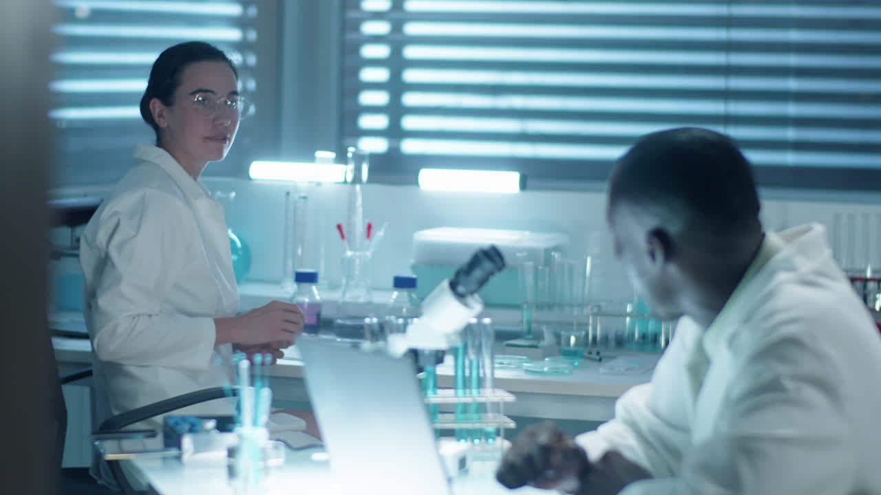 Chemist Using Laptop and Talking with Female Colleague