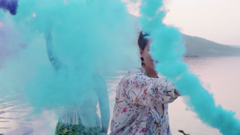 young women dancing with colored smoke bombs on lake party